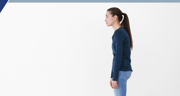 Side view of a girl standing and slouching slightly Photo